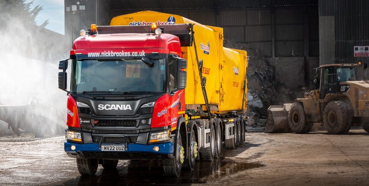 Nick Brookes Scania skip lorry with yellow skip container at a waste recycling depot in Cheshire